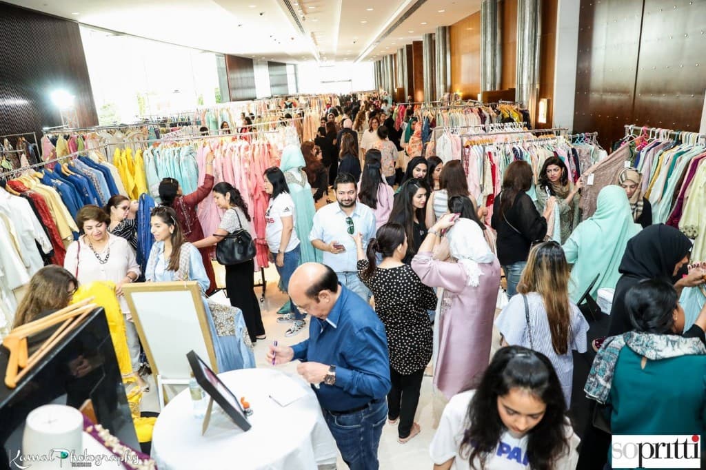 Past Sopritti exhibition — long rows of festive and designer clothing in a bright ballroom